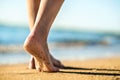 Close up of woman feet walking barefoot on sand leaving footprints on golden beach. Vacation, travel and freedom concept. People Royalty Free Stock Photo