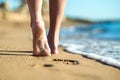 Close up of woman feet walking barefoot on sand leaving footprints on golden beach. Vacation, travel and freedom concept. People Royalty Free Stock Photo