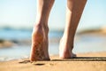 Close up of woman feet walking barefoot on sand leaving footprints on golden beach. Vacation, travel and freedom concept. People Royalty Free Stock Photo