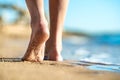 Close up of woman feet walking barefoot on sand leaving footprints on golden beach. Vacation, travel and freedom concept. People Royalty Free Stock Photo