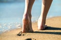 Close up of woman feet walking barefoot on sand leaving footprints on golden beach. Vacation, travel and freedom concept. People Royalty Free Stock Photo