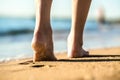 Close up of woman feet walking barefoot on sand leaving footprints on golden beach. Vacation, travel and freedom concept. People Royalty Free Stock Photo