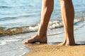 Close up of woman feet walking barefoot on sand leaving footprints on golden beach. Vacation, travel and freedom concept. People Royalty Free Stock Photo