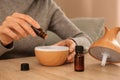 Woman filling essential oil diffuser, closeup