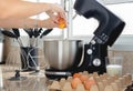 Close up of woman hand breaking an egg inside modern mixer bowl Royalty Free Stock Photo