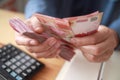 Close up of woman hand counting money uang Indonesian rupiah and making notes, money financial management Royalty Free Stock Photo