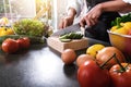 Close up of woman hand cutting salad on chopping wood board with