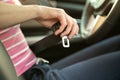 Close up of woman hand fastening seat belt while sitting inside a car for safety before driving on the road. Female driver driving Royalty Free Stock Photo