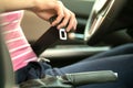 Close up of woman hand fastening seat belt while sitting inside a car for safety before driving on the road. Female driver driving Royalty Free Stock Photo