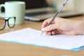 Close up of a woman hand filling form on a table