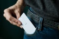 Close Up woman hand grabbing a white card in jeans pocket Royalty Free Stock Photo