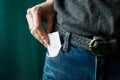 Close Up woman hand grabbing a white card in jeans pocket Royalty Free Stock Photo