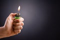 Close up woman hand holding a burning lighter in the dark background Royalty Free Stock Photo