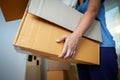 Close up on woman hand holding and carrying a cardboard box with stuffs moving to new house on moving day.