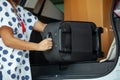 Close up on woman hand holding and carrying a suitcase moving into the car to relocation on moving day. Royalty Free Stock Photo