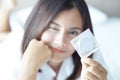 Close up woman hand holding condom with happy face lying on white bed, selective focus Royalty Free Stock Photo