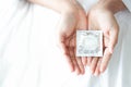 Close up woman hand holding condom lying on white bed, health care and medical concept Royalty Free Stock Photo