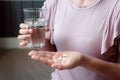 Close-Up Woman Hand is Holding Glass of Water While Taking Pills, Healthcare and Medicine Concept Royalty Free Stock Photo