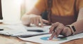 Close up woman hand holding pen and pointing at financial paperwork with financial network diagram Royalty Free Stock Photo