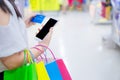 Close up woman hand holding phone, shopping bag and credit card in the shopping mall. Shopping concept Royalty Free Stock Photo