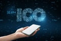 Close up of woman hand holding smartphone with glowing ICO hologram. Initial coin offering concept Royalty Free Stock Photo