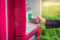 Close up woman hand inserting card into ATM. Inserting credit card into bank machine to withdraw money Royalty Free Stock Photo