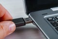 Close up of hand inserting USB flash drive into laptop computer on white background Royalty Free Stock Photo