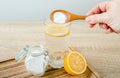 Close up of woman hand pouring baking soda in drinking glass with water and lemon juice. Royalty Free Stock Photo