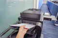 Woman hand put paper sheet into office printer tray Royalty Free Stock Photo