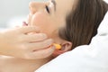 Close up of a woman hand putting ear plugs to sleep Royalty Free Stock Photo