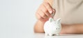 Close up of woman hand putting money coin into piggy bank for saving money. saving money and financial concept Royalty Free Stock Photo