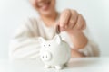 Close up of woman hand putting money coin into piggy bank for saving money. saving money and financial concept Royalty Free Stock Photo