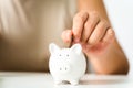 Close up of woman hand putting money coin into piggy bank for saving money. saving money and financial concept Royalty Free Stock Photo