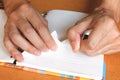 Close up woman hand ripping or tear white paper on notebook Royalty Free Stock Photo