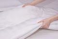 Close up woman hand set up white bed sheet in hotel room Royalty Free Stock Photo