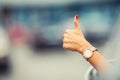 Close-up of a woman hand showing a thumbs-up sign out with car windows