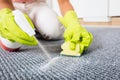 Woman Spraying Detergent On The Carpet