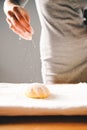 Woman hand sprinkling flour on fresh dough Royalty Free Stock Photo