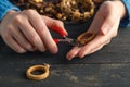 Close up of woman hand threading beads on drawstring to make artistic bead necklace or bracelet