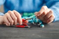 Close up of woman hand threading beads on drawstring to make artistic bead necklace or bracelet