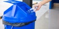 Close up woman hand throwing empty plastic water bottle into recycling bin Royalty Free Stock Photo