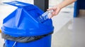 Close up woman hand throwing empty plastic water bottle into recycling bin Royalty Free Stock Photo