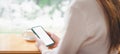 Close-up of woman hand using mockup white screen mobile phone at cafe with clipping path. Focus on mobile phone,Soft focus Royalty Free Stock Photo