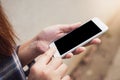 Close up woman hand using smart mobile phone with blank display on concrete wall background. Royalty Free Stock Photo