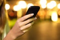 Close up of a woman hand using a smart phone in the night Royalty Free Stock Photo