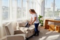 Close up of woman hand with vacuum cleaner, copy space. Woman cleaning sofa with vacuum cleaner. Household and spring-cleanig.