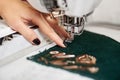 Close-up of woman hand working on sewing machine creating colorful floral pattern on textile detail. Royalty Free Stock Photo