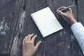 Close up woman hand writing on notebook. Woman writing on note paper diary on wooden table Royalty Free Stock Photo