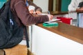 Close up of a woman hand writing or signing in a document on a reception zone of clinic. Selective focus Royalty Free Stock Photo