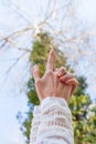 Close up woman hand in yoga mudra gesture from below view to the sky and tree